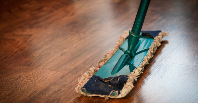 A detailed view of a mop cleaning a wooden floor, showing texture and pattern.